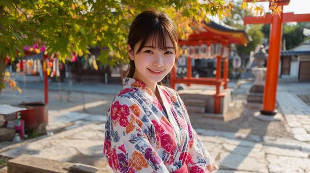 神社の境内にいる浴衣姿の若い女性 神社の境内にいる浴衣姿の若い女性の写真