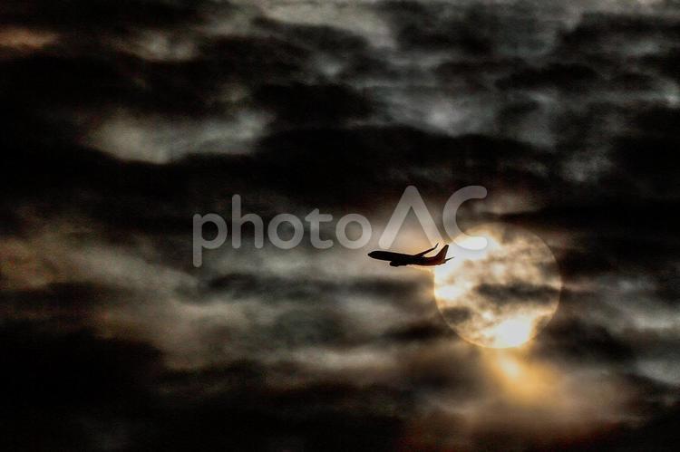 夕暮れ太陽と重なった瞬間の飛行機の影 太陽,飛行機,空の写真素材