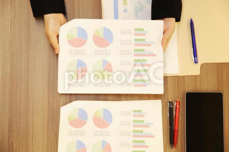 企画書書類を説明する女性の手とタブレットPCと木目の机-俯瞰 女性,人物,ビジネスの写真素材