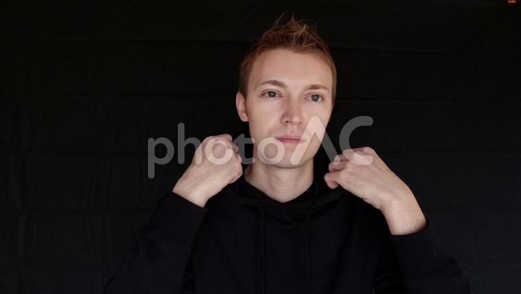 かっこつけのポーズをしている男　外国人男性　黒バック かっこをつけてる,ジェスチャー,かおの写真素材