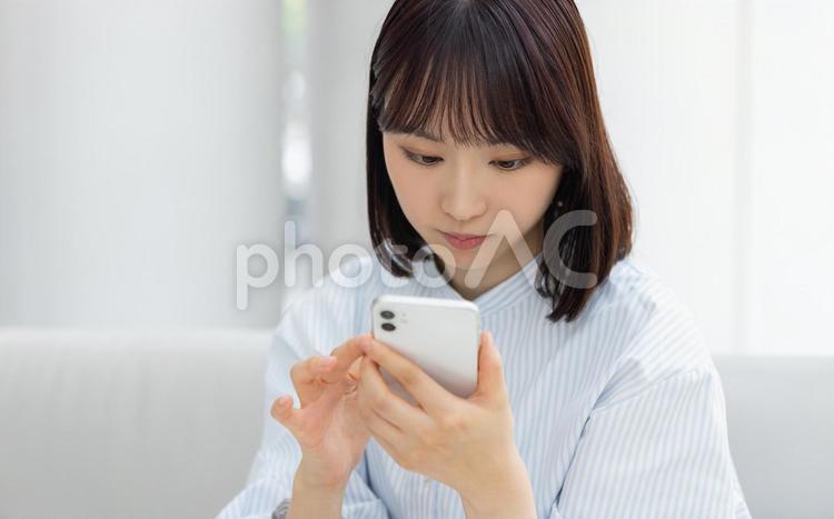 スマホを操作する若いビジネスウーマン 女性,ビジネス,スマホの写真素材