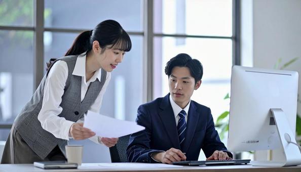 上司に資料を確認する女性社員 上司に資料を確認する女性社員の写真
