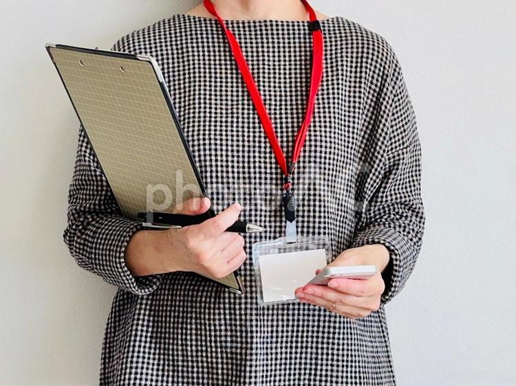 クリップボードとスマホを持った仕事中の女 仕事中,女性,調査員の写真素材