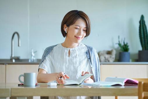 イヤホンをつけて勉強をする女性 勉強,女性,学習の写真素材