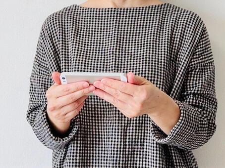 スマホを横向きにして動画を視聴する女性 スマホ,横向き,動画の写真素材