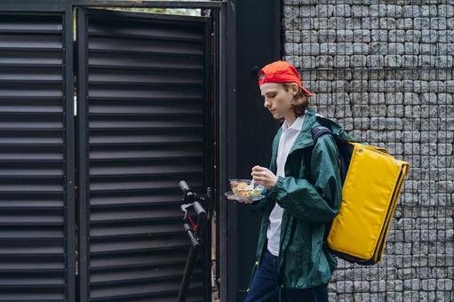 サラダを食べるフードデリバリーの男性 配達,フードデリバリー,デリバリーの写真素材