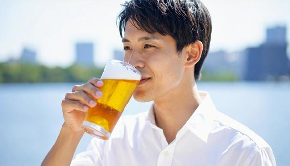 ビールを飲む若い男性のポートレート ビールを飲む若い男性のポートレートの写真