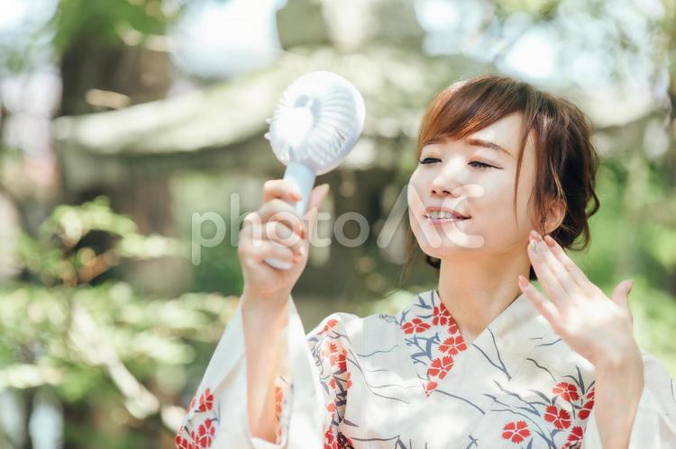 扇風機を持つ浴衣姿の女性 浴衣,暑い,ハンディファンの写真素材