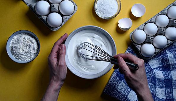 お菓子作りでクリームを泡立てている手元の写真