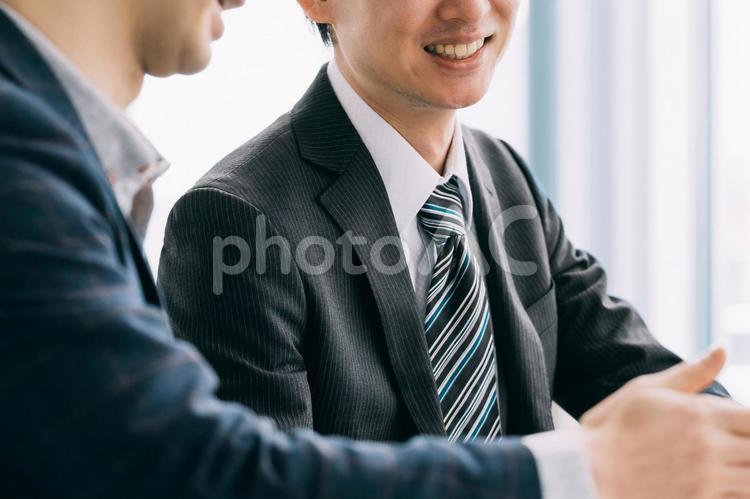 パソコンを見て話す2人の男性ビジネスマン 男性,ビジネス,ビジネスマンの写真素材