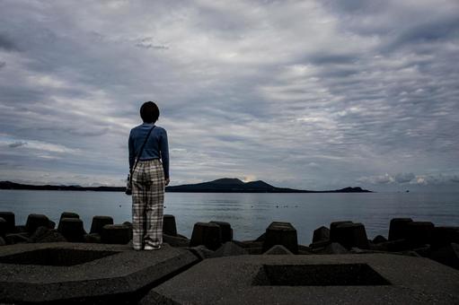 ＜素材＞秋の海辺を散策する女性の後ろ姿 女性,悩む,海の写真素材