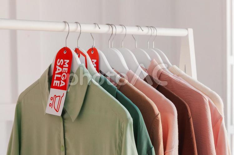 洋服屋のセールのタグの付いたハンガーに掛かった洋服 セール,ショップ,人物なしの写真素材