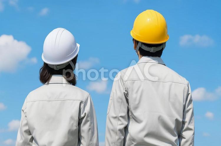 青空を見上げる作業員の後ろ姿・安全第一 作業員,建築業,現場の写真素材