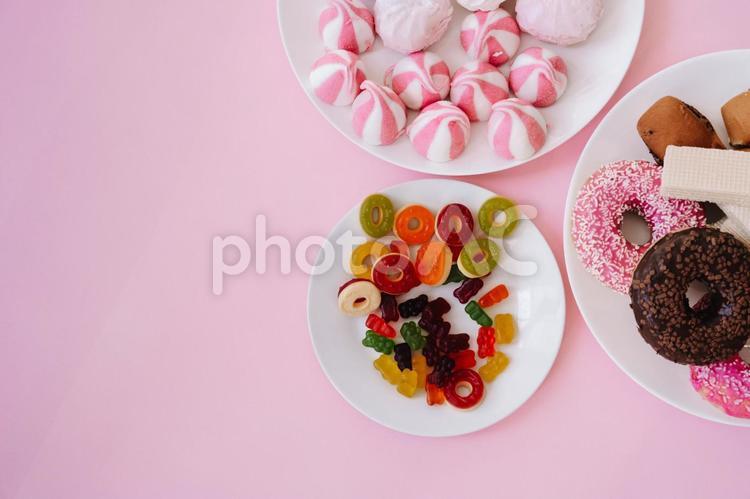 ピンクの背景にドーナツやマシュマロやグミなど ドーナツ,ウェハース,パンの写真素材
