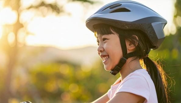 自転車用ヘルメットをかぶる女の子 自転車用ヘルメットをかぶる女の子の写真
