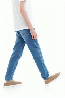 歩いているTシャツにジーンズの人(下半身) 歩いているTシャツにジーンズの人(下半身)の写真