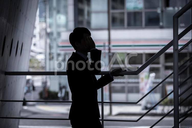 頭を抱える男性のシルエット　Shadow 男性,悩み,泣くの写真素材