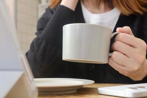 タブレットを見ながらコーヒーを飲む女性 タブレットを見ながらコーヒーを飲む女性 カフェ,女性,コーヒーの写真素材