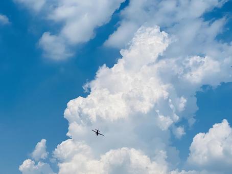 巨大積雲の下を飛ぶ航空機 巨大積雲の下を飛ぶ航空機 飛行機,航空機,小型機の写真素材