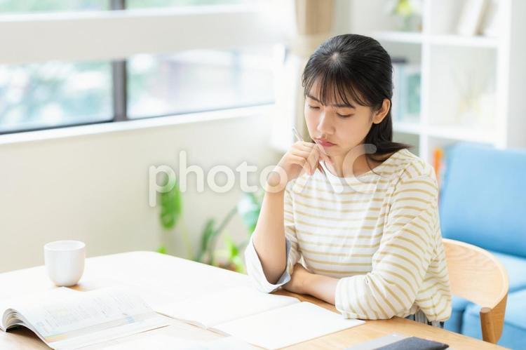 リビングで勉強をする大学生の女性 教育,勉強,女性の写真素材