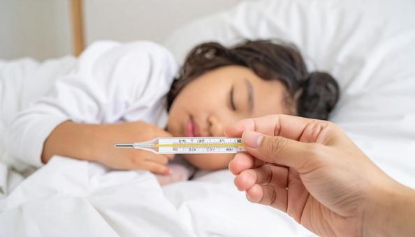 体温計を持つ母親の手と体調不良の子供 体温計を持つ母親の手と体調不良の子供の写真