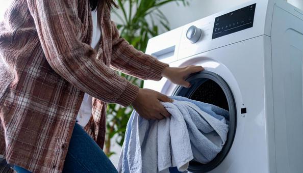 洗濯機から洗濯物を取り出す女性の手 洗濯機から洗濯物を取り出す女性の手の写真