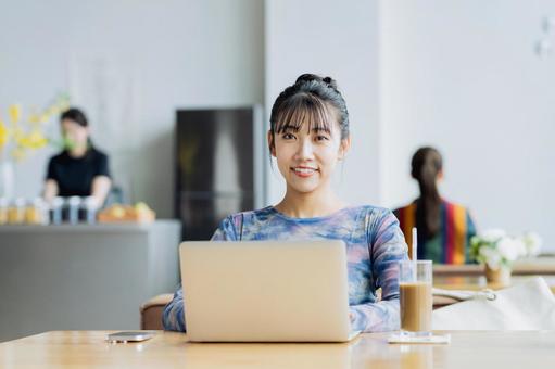 カフェで働くフリーランスの若い女性 カフェで働くフリーランスの若い女性の写真