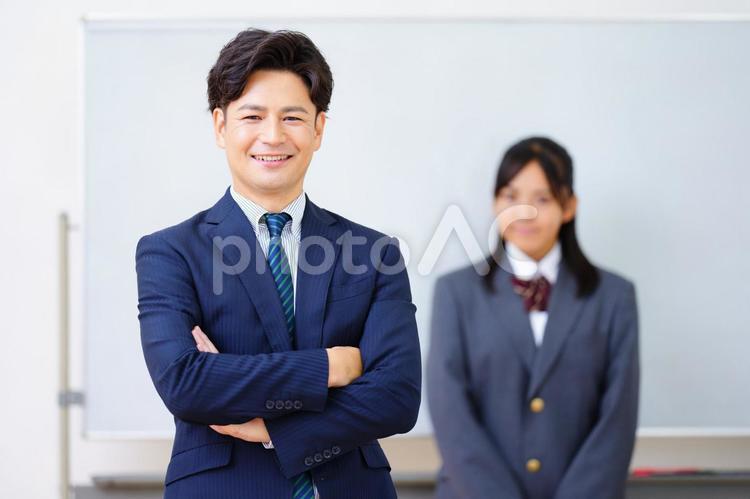 腕組みするカメラ目線の塾講師と女子生徒 塾,人物,男性の写真素材