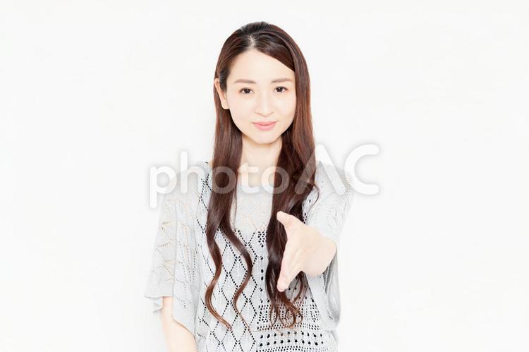 握手で手を差し出すカジュアルな服装の女性 握手,女性,手の写真素材
