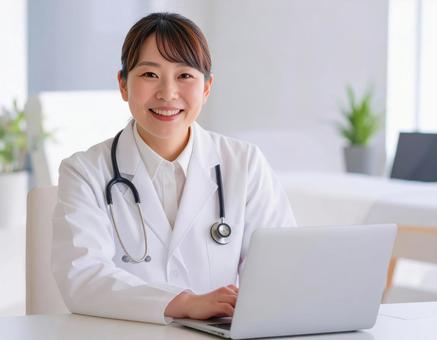 診察室でパソコンを操作する白衣の女性医師 診察室でパソコンを操作する白衣の女性医師の写真