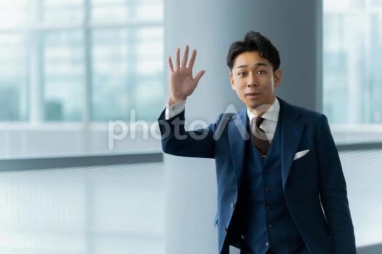 知り合いを見つけて挨拶をするビジネスマン ビジネス,男性,ビジネスマンの写真素材