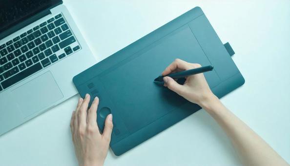 ペンタブレットで絵を描く女性の手もと ペンタブレットで絵を描く女性の手もとの写真