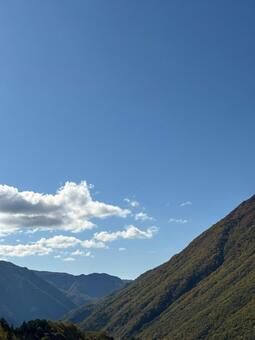 秋空に映える山の稜線と紅葉の風景 山,紅葉,秋の写真素材
