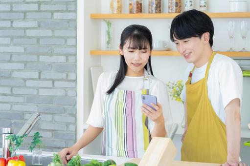 キッチンで料理を作る若い夫婦 キッチンで料理を作る若い夫婦 夫婦,料理,キッチンの写真素材