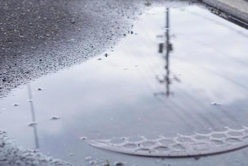 水たまりに反射するくもり空と電柱 水たまりに反射するくもり空と電柱 水たまり,曇り,雨の写真素材