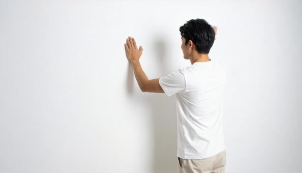 白い壁にぶつかる日本人男性 白い壁にぶつかる日本人男性の写真