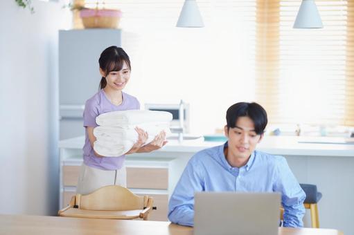 男性の方を見るタオルを運ぶ笑顔の女性 男性の方を見るタオルを運ぶ笑顔の女性の写真
