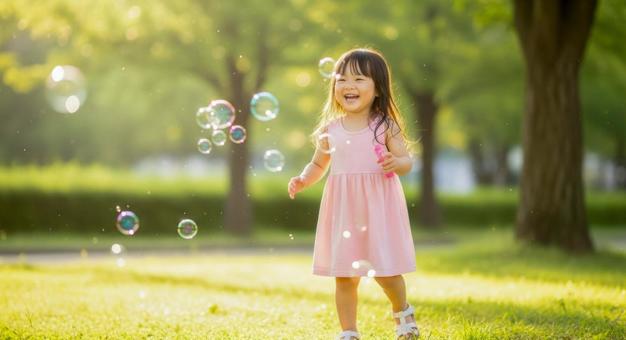 シャボン玉で遊ぶ笑顔の女の子 シャボン玉で遊ぶ笑顔の女の子の写真