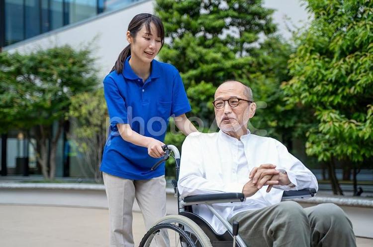 車いすのシニア男性と介護施設スタッフ シニア,車椅子,介護の写真素材