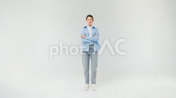 腕組みをして立つジーンズの女性 女性,腕組み,真顔の写真素材