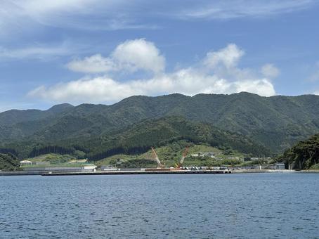 海越しに見る山と工事現場 海越しに見る山と工事現場 海,山,建設現場の写真素材