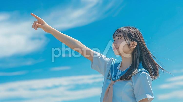 遠くの目標を力強く指さす制服姿の女の子　 女子高生,女子生徒,指さすの写真素材