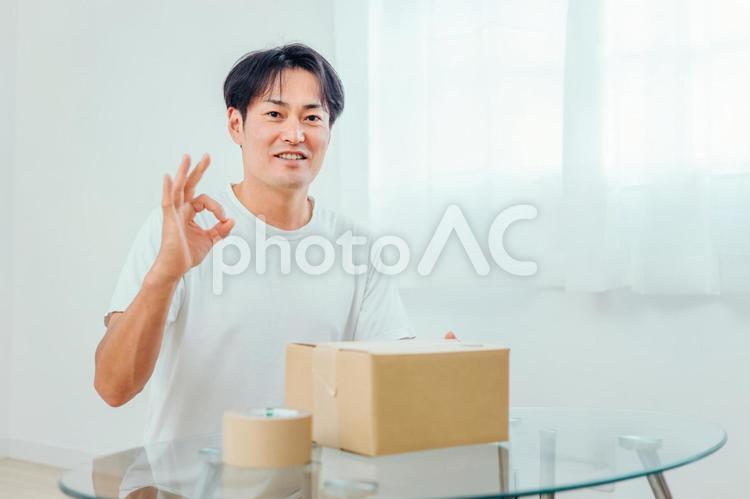 段ボールを開ける男性（笑顔） 荷造り,宅急便,宅配便の写真素材