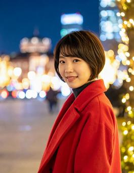 クリスマスツリーと赤いコートの彼女の写真