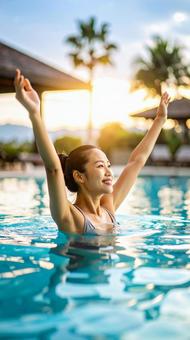 プールで両手を広げ伸びをする女性の写真