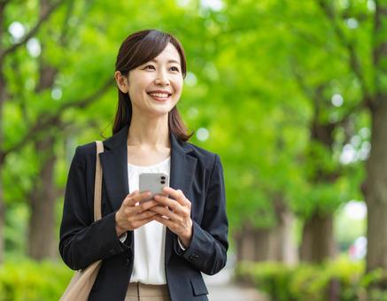 スマホを持っている女性 スマホを持っている女性の写真