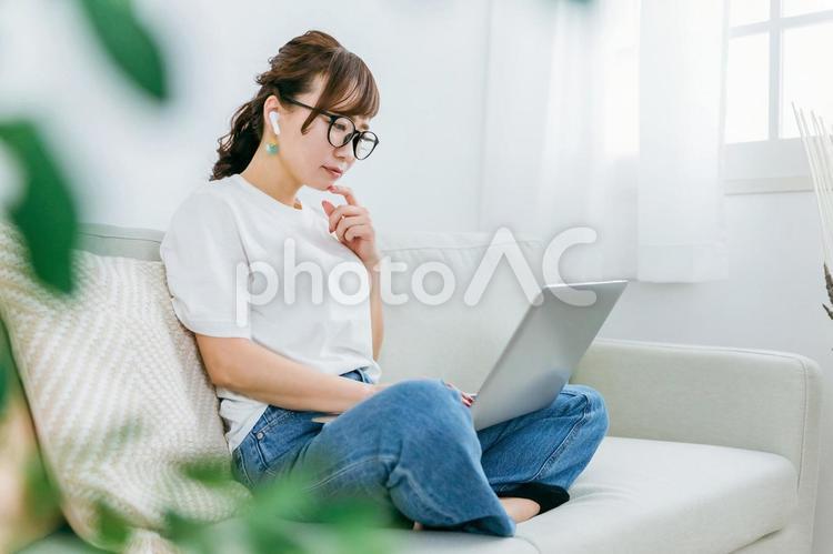 イヤホンとパソコンを使って困る日本人女性 パソコン,イヤホン,耳の写真素材