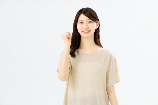 笑顔でガッツポーズをする若い女性の写真
