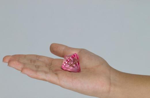 手のひらに乗せた大きなピンクの宝石 手のひらに乗せた大きなピンクの宝石の写真