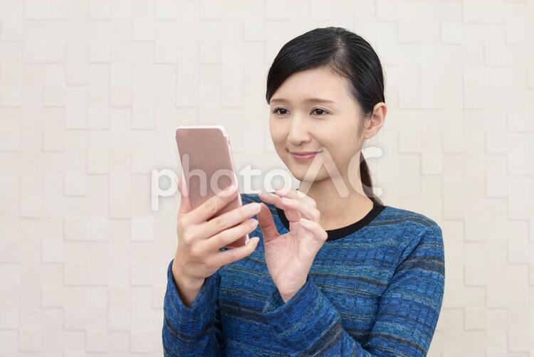スマートフォンを持つ笑顔の女性 女性,スマートフォン,女の写真素材
